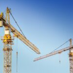 Picture of cranes making construction changes as a lead-in to what changes are allowed for CMMC before a reassessment is required